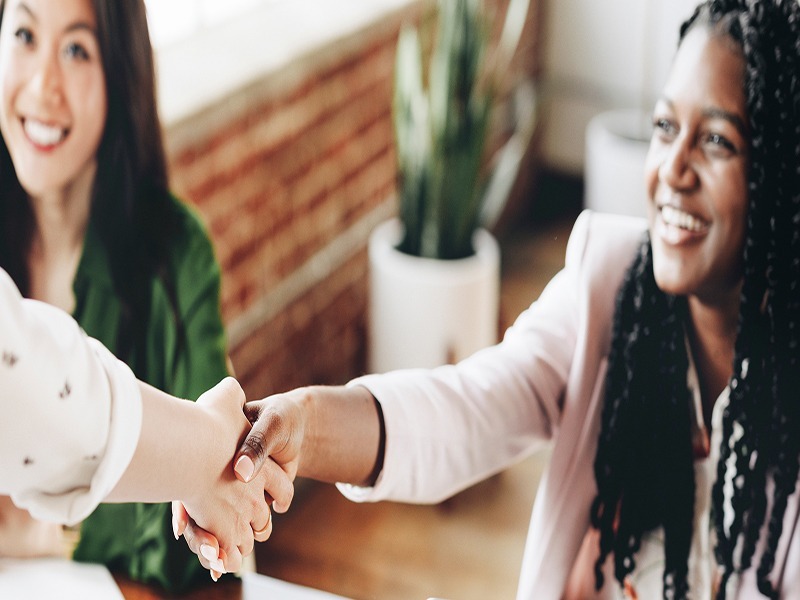 A woman is happy while shaking hands